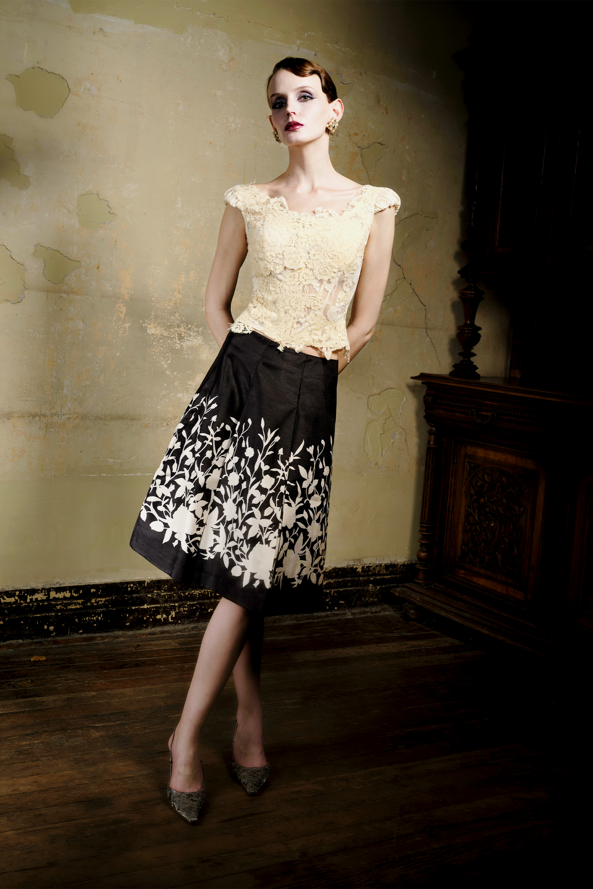 Black A-line pleated skirt with cream floral print at hem, front view