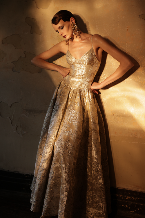 Woman wearing gold metallic jacquard ball gown with sweetheart neckline by Yingtong