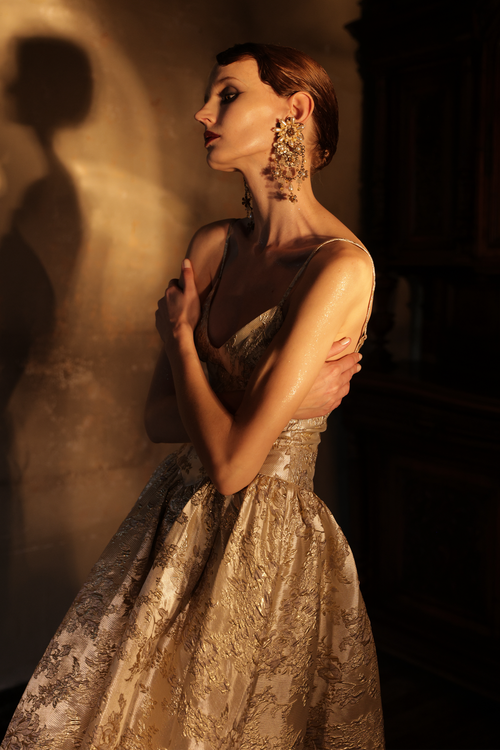 Woman wearing gold metallic jacquard ball gown with sweetheart neckline by Yingtong