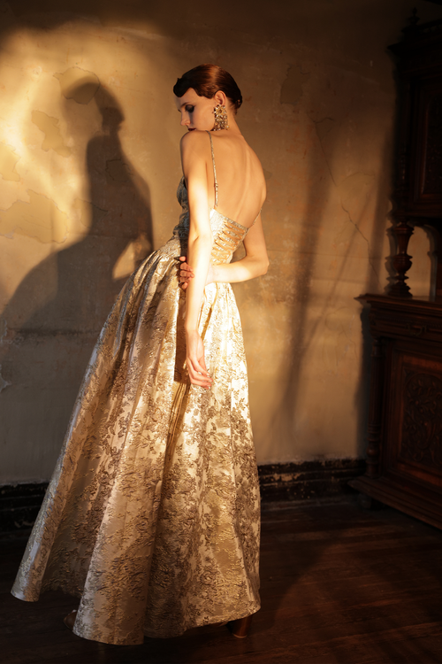 Woman wearing gold metallic jacquard ball gown with sweetheart neckline by Yingtong