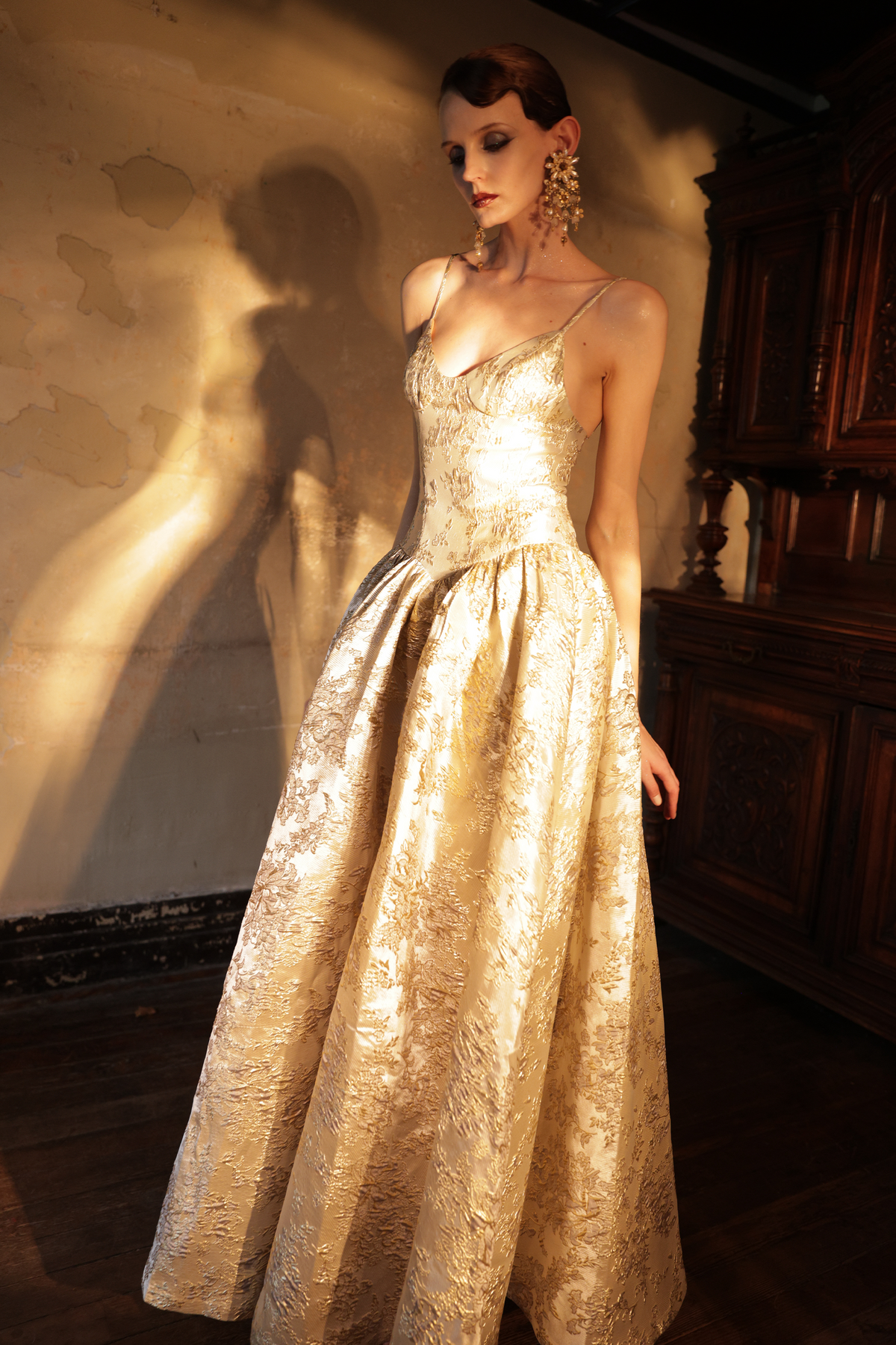 Woman wearing gold metallic jacquard ball gown with sweetheart neckline by Yingtong