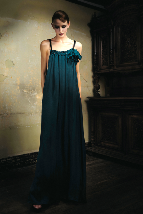 Woman wearing emerald cupro slip dress with handmade frayed flower applique at bust