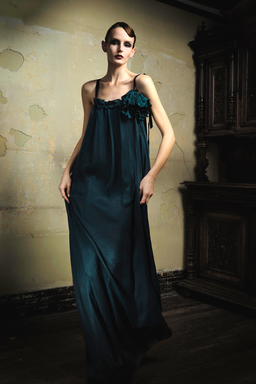 Woman wearing emerald cupro slip dress with handmade frayed flower applique at bust