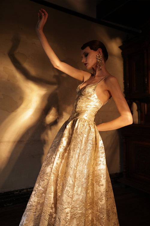 Woman wearing gold metallic jacquard ball gown with sweetheart neckline by Yingtong