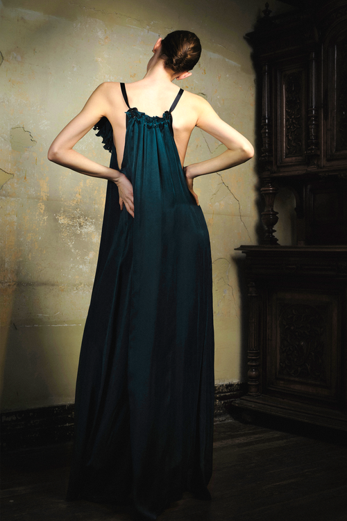 Woman wearing emerald cupro slip dress with handmade frayed flower applique at bust
