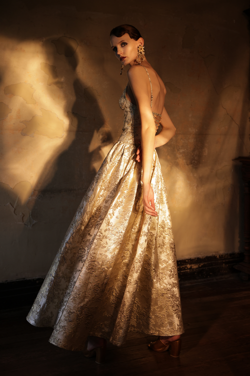 Woman wearing gold metallic jacquard ball gown with sweetheart neckline by Yingtong
