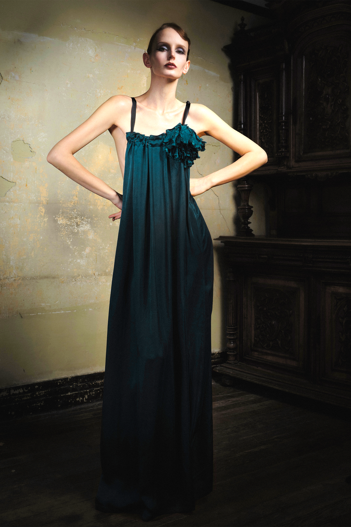 Woman wearing emerald cupro slip dress with handmade frayed flower applique at bust