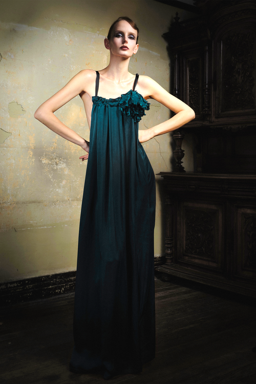 Woman wearing emerald cupro slip dress with handmade frayed flower applique at bust