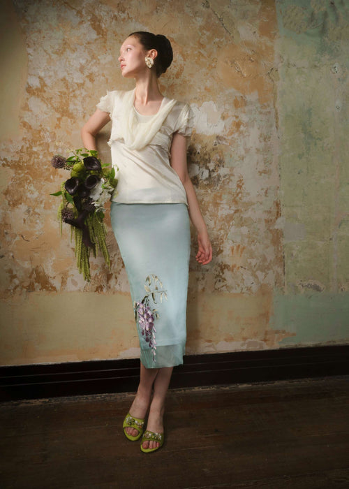Mint silk organza embroidered midi skirt styled with an ivory blouse and a bouquet of green florals